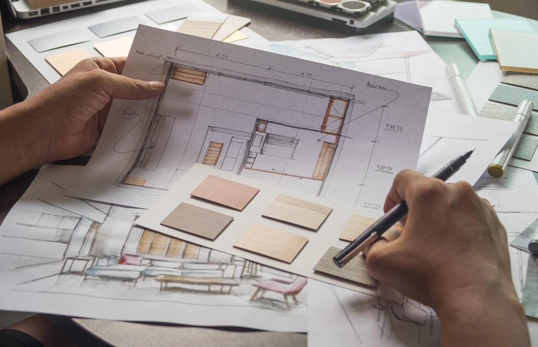 Builder and designer comparing stone, tile and wood samples against construction drawings